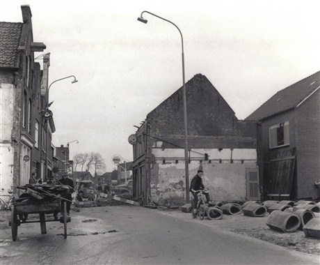 Werkzaamheden tijdens de verbreding van de Oosterstraat, 1961. De nieuwbouw is al zichtbaar achter de oude rij. Begin 1962 waren alle panden gesloopt en kon de nieuwe weg worden aangelegd (archief Stichting Oud Nijkerk). 