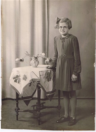 Dit is Annie in 1942. In deze kleding van de St. Vincentiusvereniging deed ze haar plechtig aannemen. Ze schaamde zich voor deze jurk, iedereen droeg hem. Moeder heeft het kraagje iets veranderd en de taille en zoom geborduurd.
