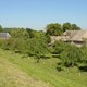 Het landschap van de oeverwal: het gehucht Heesselt, gezien vanaf de Waalbandijk. De lichte, zandige, kleigrond is ideaal voor tuinbouw, akkerbouw en fruitteelt. © Foto Overland, CHW Gelderland-521, 2003